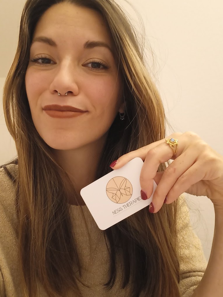 photo de Vanessa Henriques souriante et tenant une carte de visite dans sa main