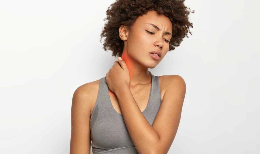 A woman holding her neck, symbolizing relief from physical tension and pain through kinesiology